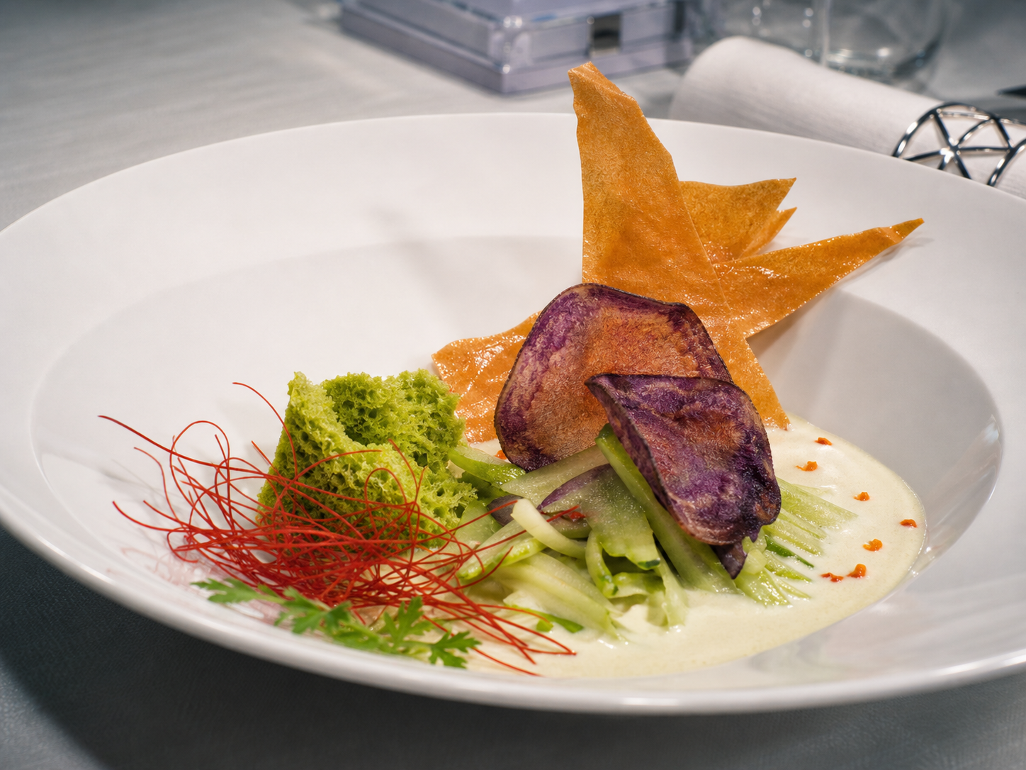 Secondo con verdure verdi, chips croccanti e crema chiara